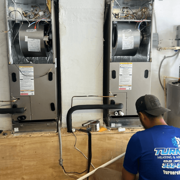 Technician inspecting HVAC units in a maintenance room.