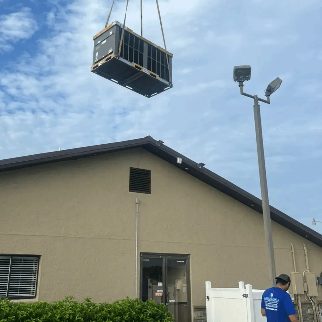 Crate being lifted by crane over a building under a partly cloudy sky.